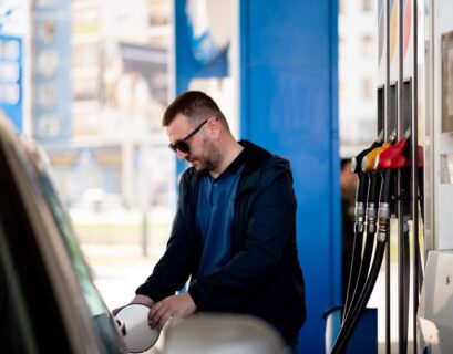 a man with a blue jacket and dark glasses at a gas filling gas or AdBlue 2023 11 27 05 12 52 utc 1